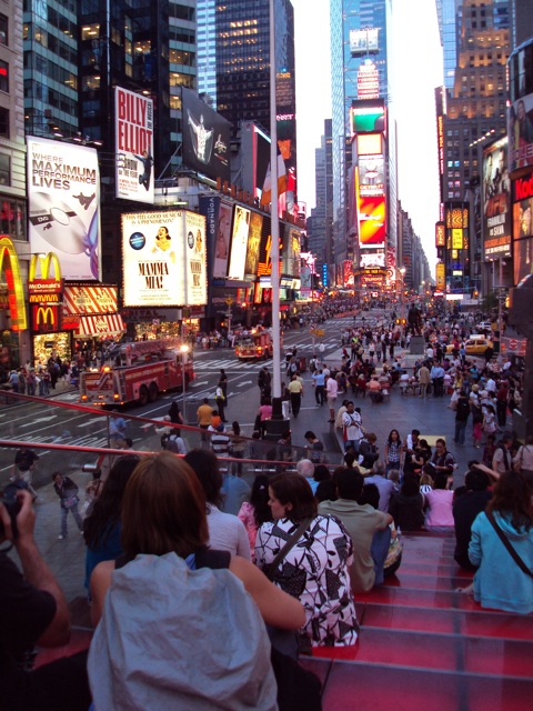 A fire truck making its way through traffic on Times Square